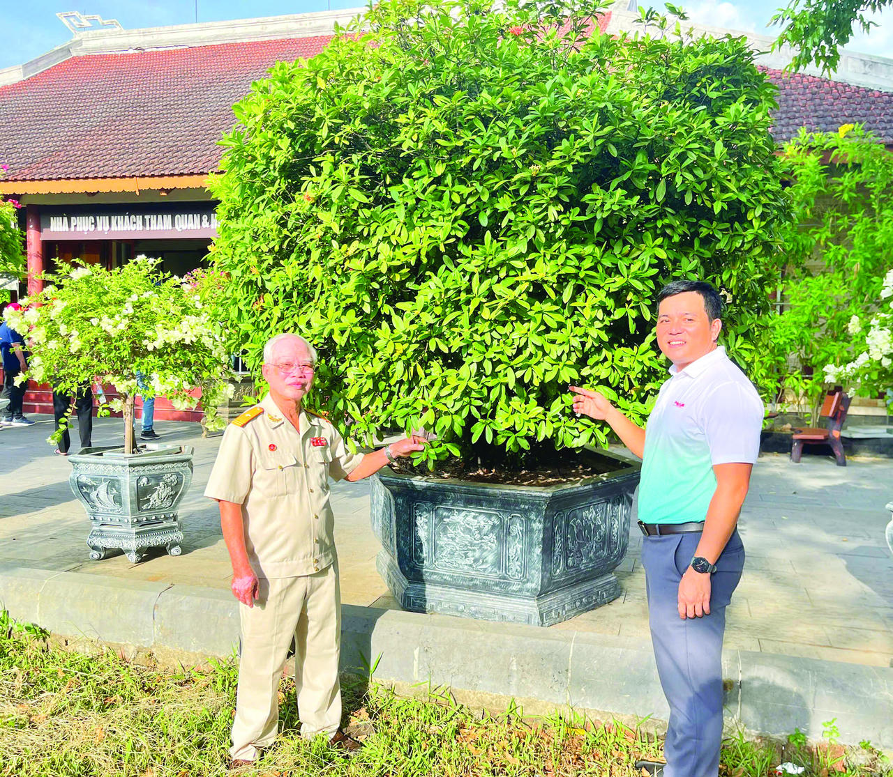 Nhà thơ, nhà báo, cựu chiến binh Lê Bá Dương (bên trái) và nhà báo Lê Văn Hoàng Tám Bảy bên cây mẫu đơn trong sân Thành cổ Ảnh: Minh Phương