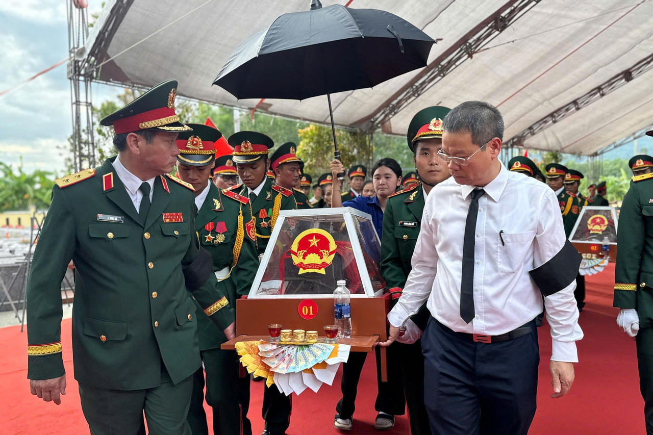 Đồng đội và lãnh đạo địa phương cùng tiễn đưa các liệt sĩ trong giây phút trở về đầy xúc động (Ảnh: Vân Anh)