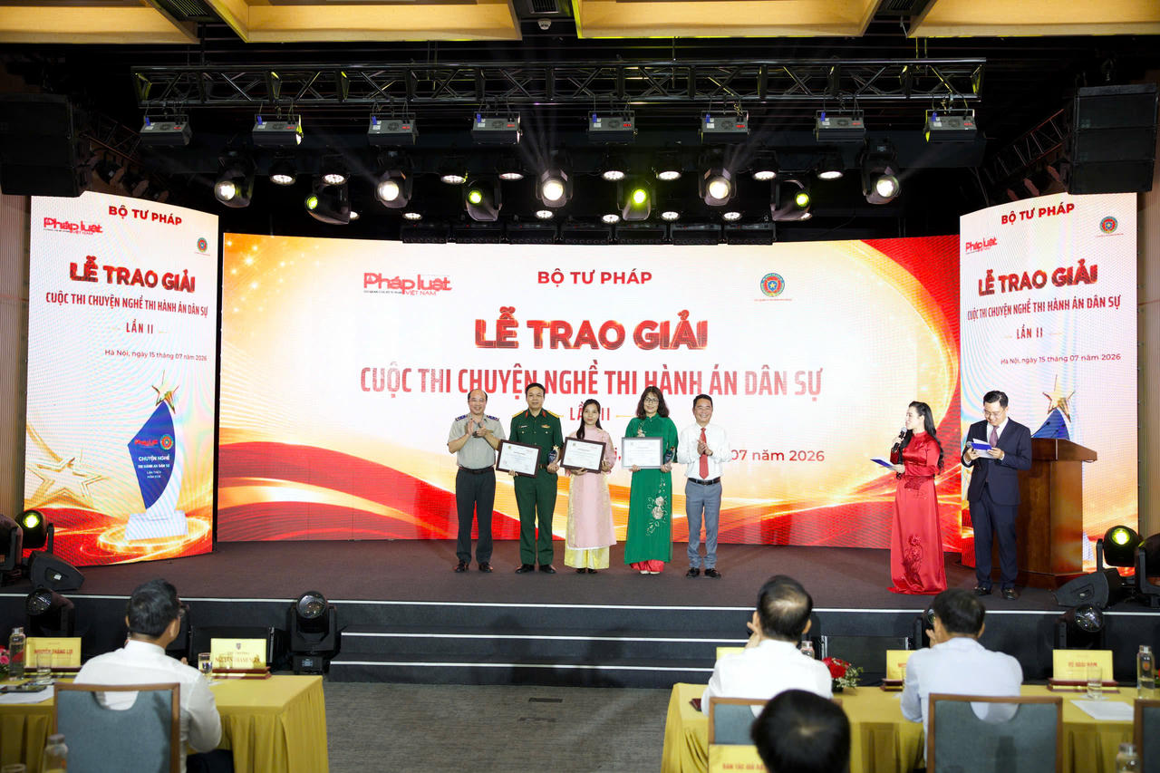 Cục trưởng Cục Quản lý THADS Nguyễn Thắng Lợi và Tổng Biên tập Báo Pháp luật Việt Nam Vũ Hoài Nam trao giải cho nhóm tác giả giải B Cuộc thi Chuyện nghề THADS lần thứ 2