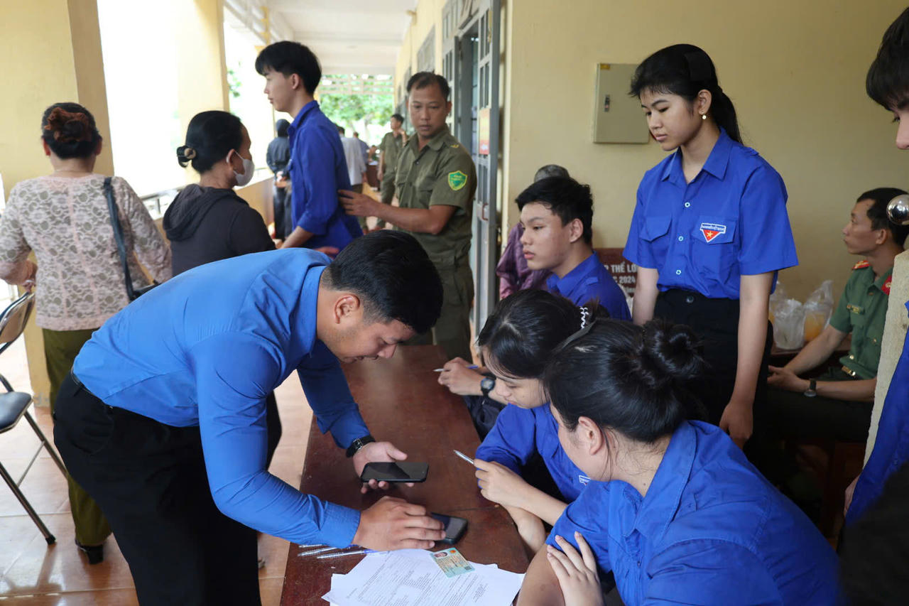 Lực lượng Đoàn thanh niên địa phương hỗ trợ hướng dẫn thân nhân liệt sĩ thu nhận mẫu diễn ra đúng quy định (Ảnh: Vân Anh)