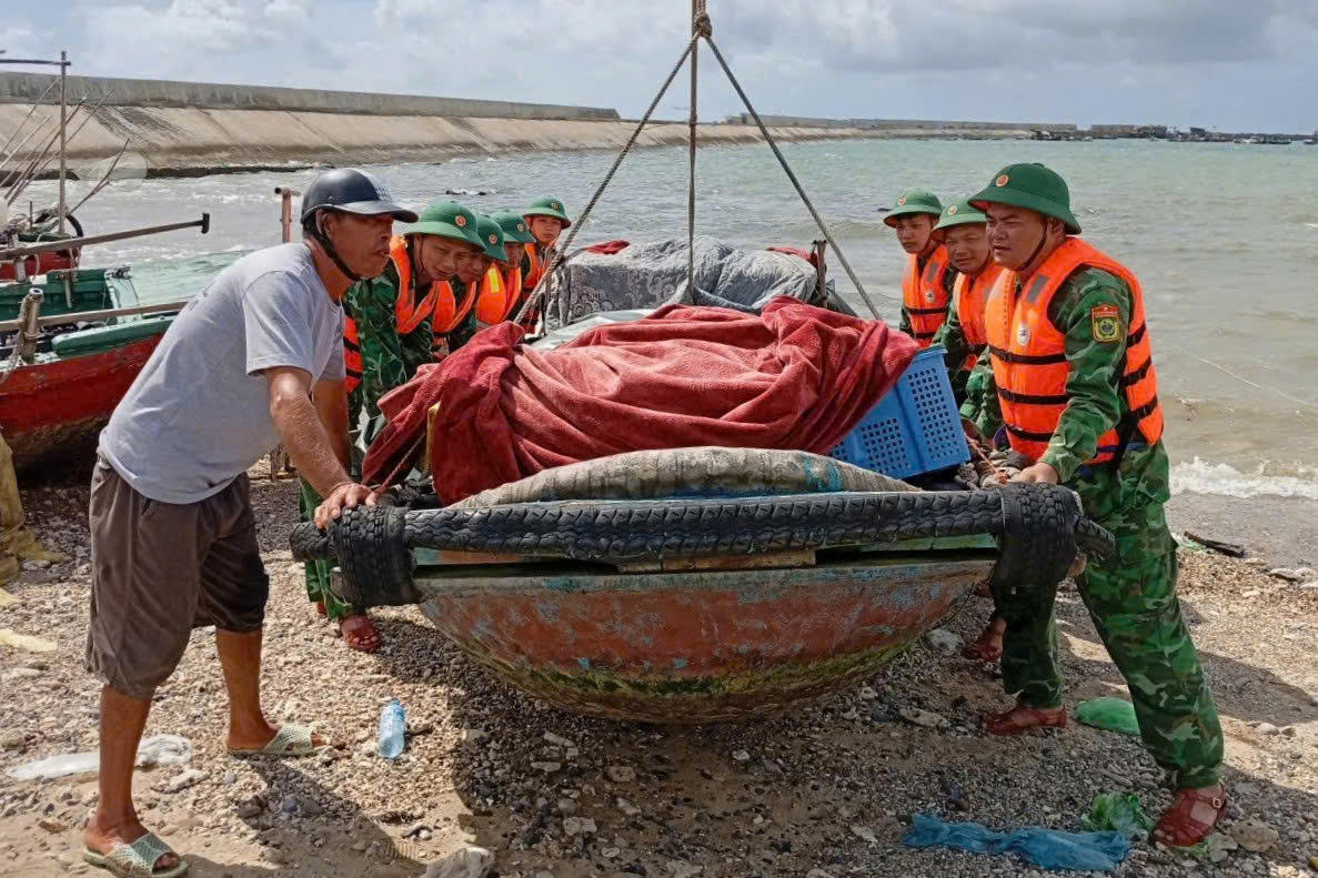 Cán bộ, chiến sĩ Bộ đội Biên phòng thành phố Hải Phòng hỗ trợ người dân đưa tàu thuyền lên bờ, phòng tránh thiệt hại do bão số 1.