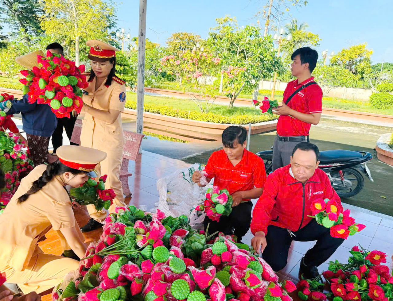 Cán bộ, chiến sĩ Phòng CSGT, Phòng Tham mưu Công an tỉnh Cà Mau cùng cán bộ, nhân viên Viettel Cà Mau lựa chọn những đóa hoa sen để thay mới trên các phần mộ liệt sĩ tại Nghĩa trang Liệt sĩ.