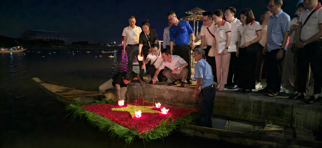 Tiến sĩ Vũ Hoài Nam - tổng biên tập Báo PLVN cùng các cán bộ, phóng viên, biên tập viên thả hoa tưởng niệm bên bến sông Thạch Hãn.