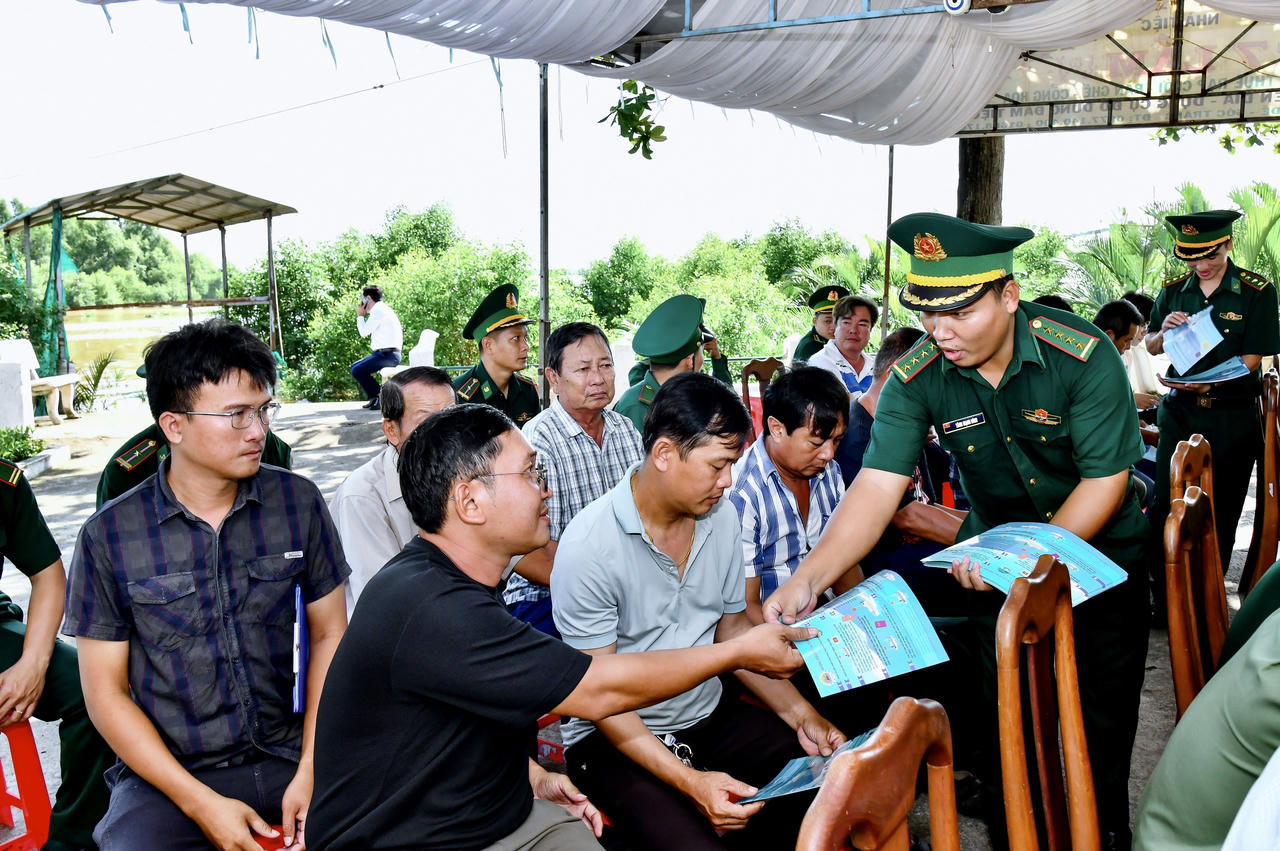 Cán Bộ đồn Biên phòng Trung Bình cấp phát tờ rơi tuyên truyền chống khai thác IUU cho bà con ngư dân tham dự lễ ra quân. Ảnh: Văn Long