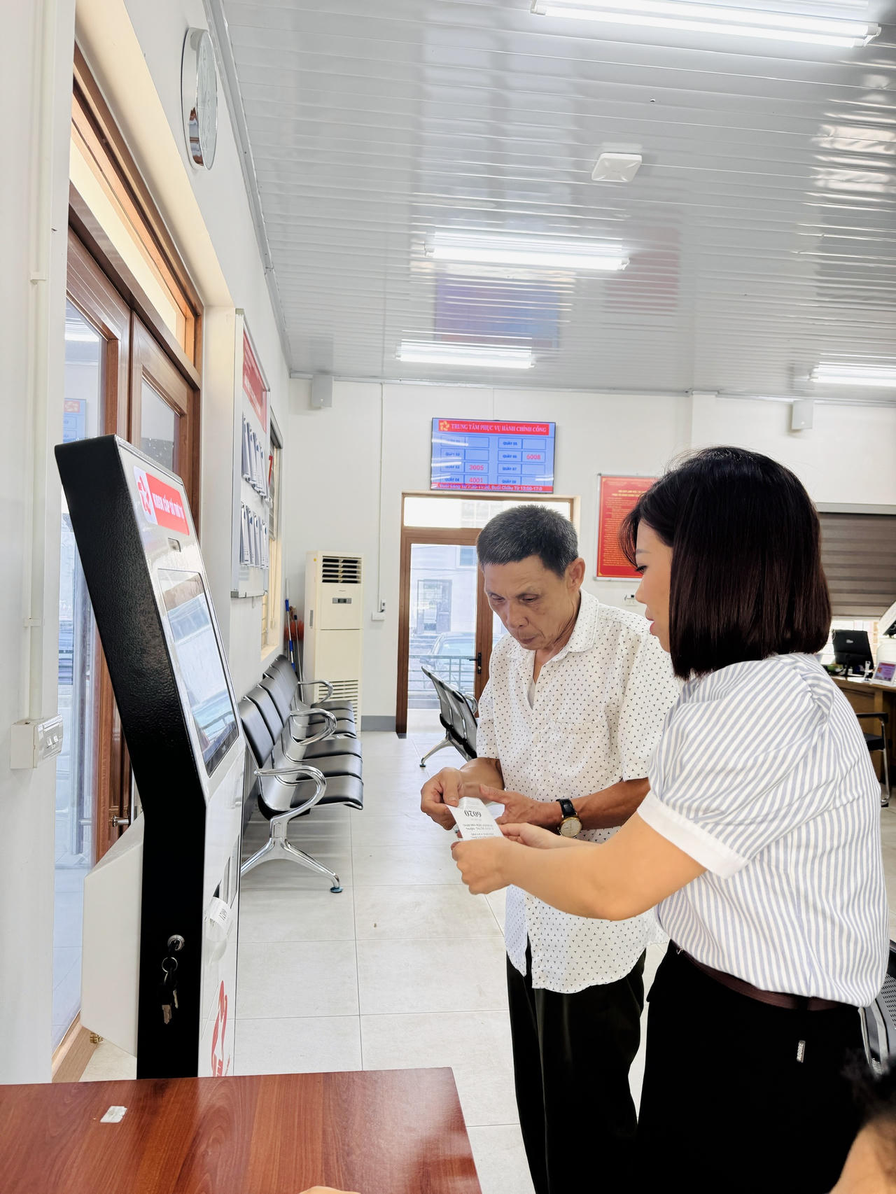 Người dân được cán bộ Trung tâm Phục vụ hành chính công phường Vân Phú hướng dẫn, giải quyết thủ tục hành chính theo cơ chế một cửa.