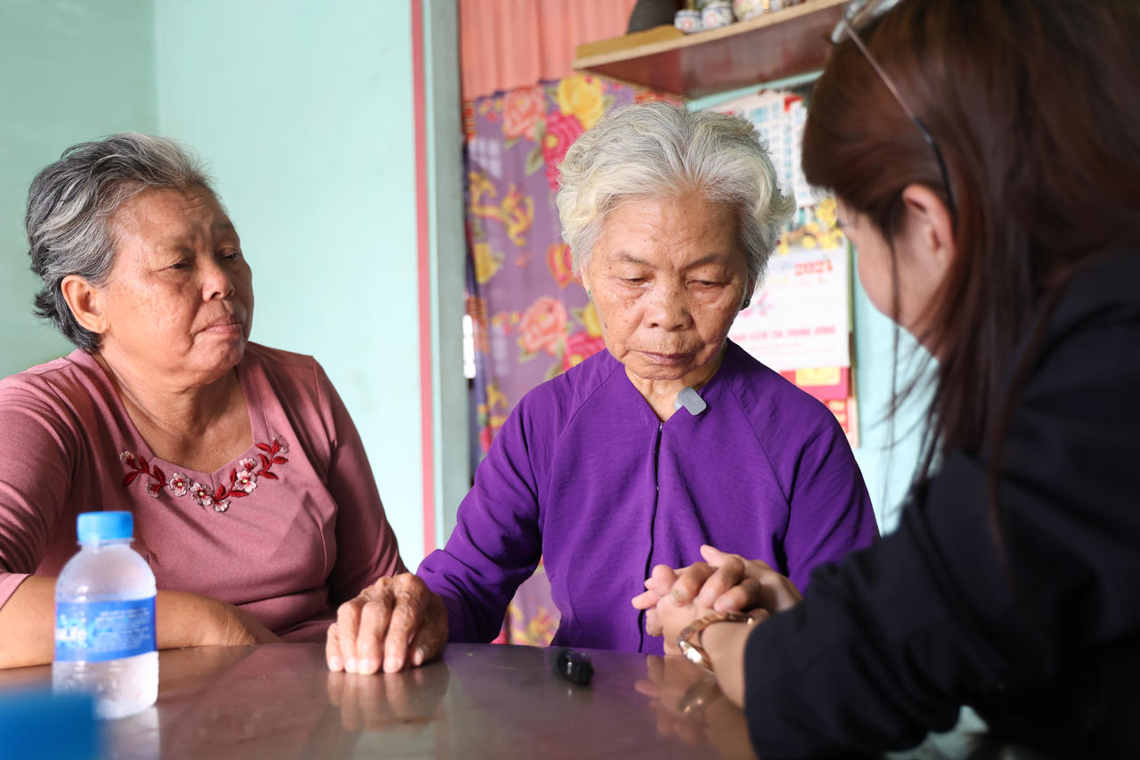 Bà Nguyễn Thị Lệ (ngồi giữa - áo tím), nghẹn ngào giới thiệu, “từ nay, tôi là vợ liệt sĩ Huỳnh Văn Quên”. (Ảnh: Xuân Sang)