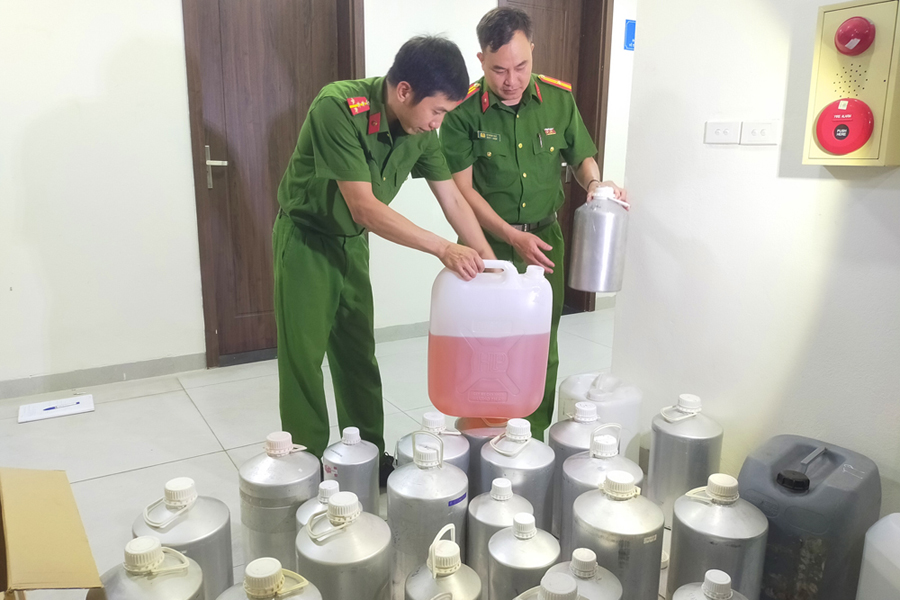 Những can hương liệu, nước hoa giả được các đối tượng dùng để sản xuất, sang chiết nước hoa thương hiệu giả. (Ảnh: Bộ Công an)