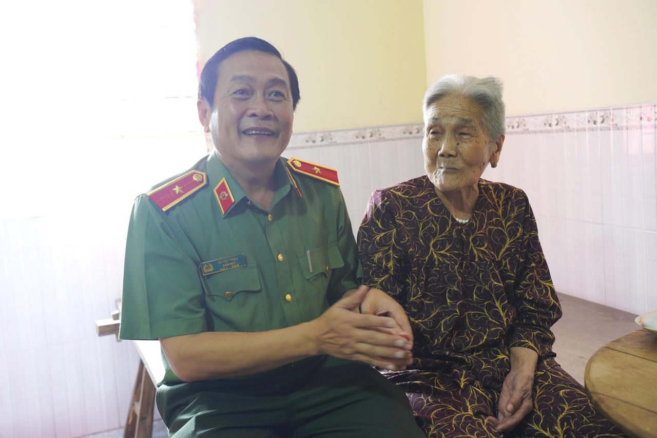 Thiếu tướng Hồ Việt Triều, ân cần thăm hỏi sức khỏe Mẹ Việt Nam Anh hùng Lê Thị Dồi. (Ảnh: Hữu Đệ).
