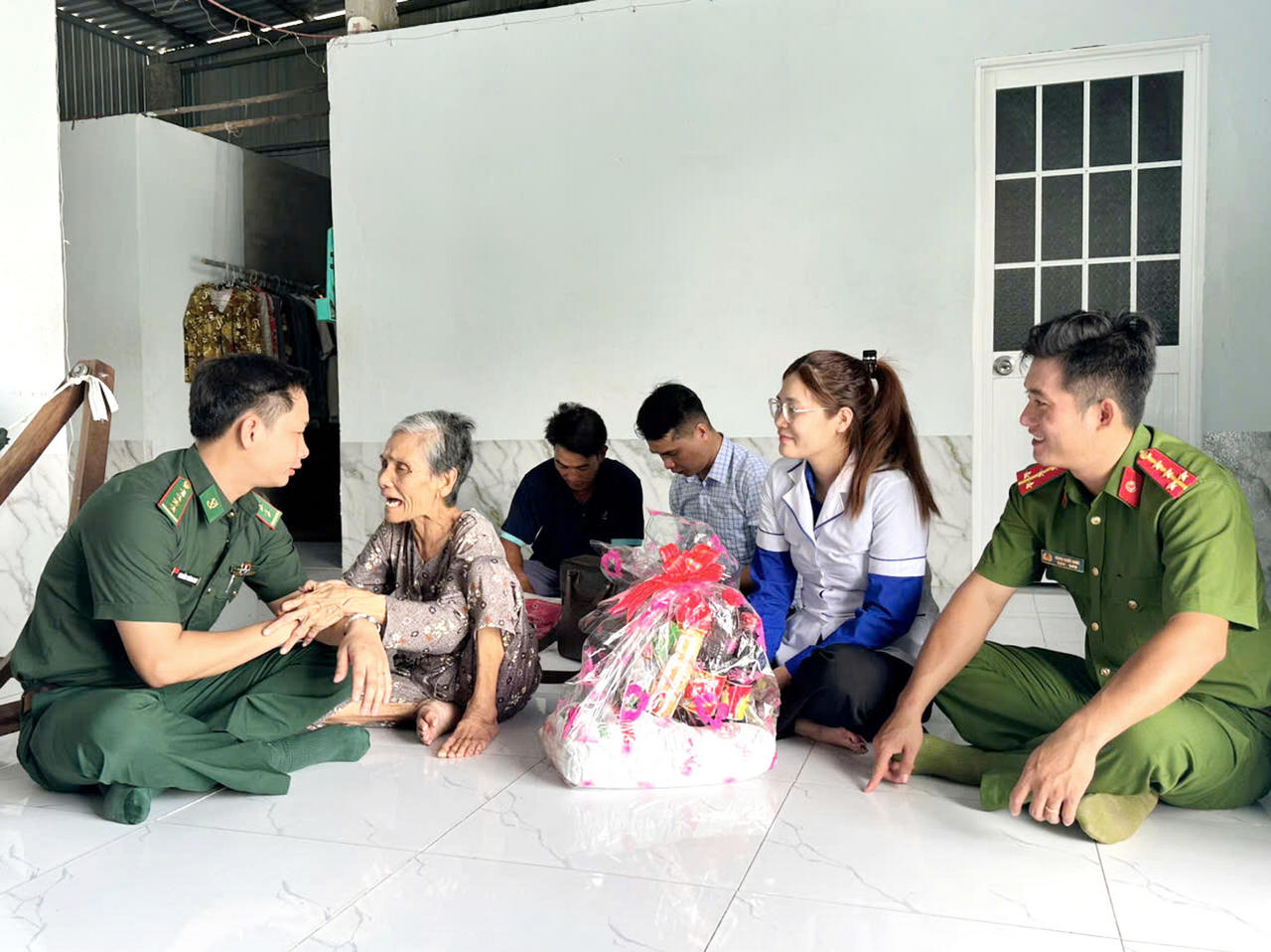 Cán bộ Đồn Biên phòng Cái Đôi Vàm phối hợp cùng chính quyền địa phương thăm hỏi, động viên, tặng quà bà Nguyễn Thị Thắng, vợ liệt sĩ (ngụ ấp Tân Quảng Tây, xã Cái Đôi Vàm) - Ảnh: Tá Yên.