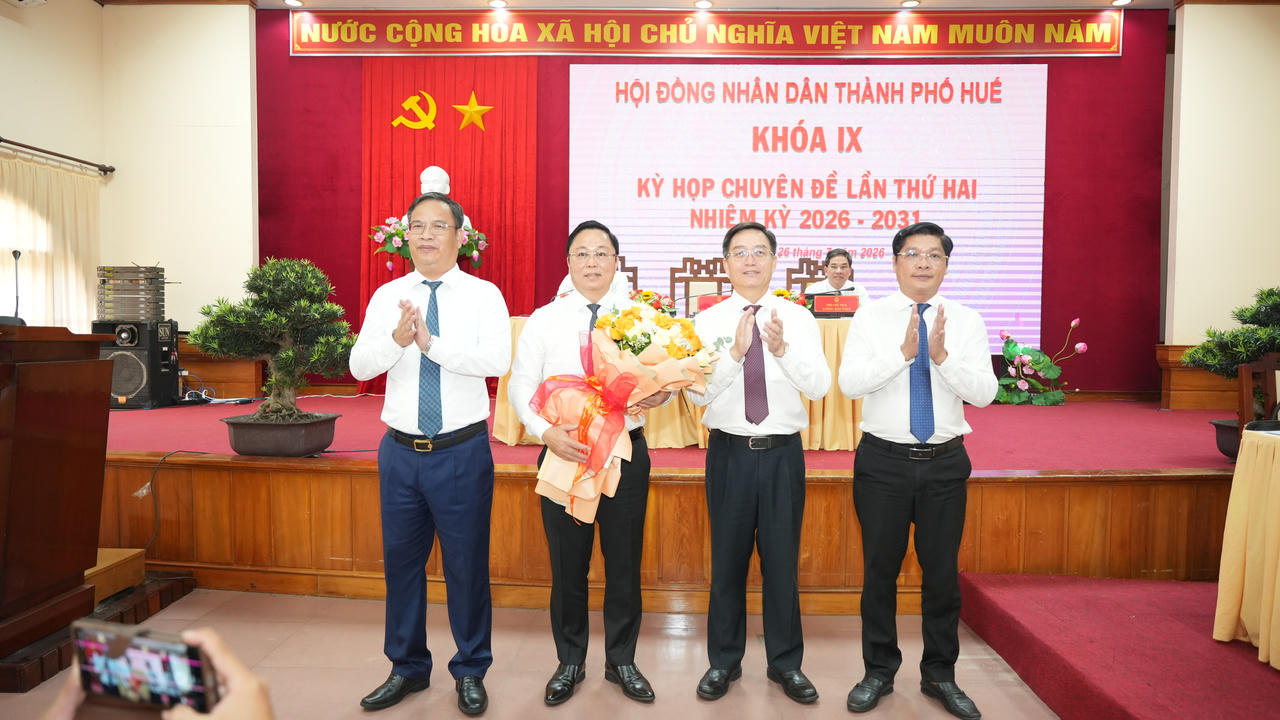 Lãnh đạo thành phố tặng hoa chúc mừng tân Chủ tịch UBND thành phố Huê Lê Trí Thanh. (Ảnh: Ng. Minh)
