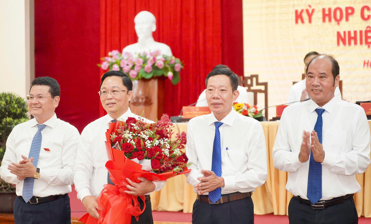 Lãnh đạo thành phố tặng hoa chúc mừng tân Chủ tịch UBND thành phố Huê Lê Trí Thanh. (Ảnh: Ng. Minh)
