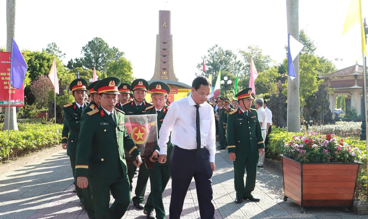 Đại biểu và lực lượng vũ trang tiễn đưa hài cốt liệt sĩ về nơi an nghỉ cuối cùng. (Ảnh: Lê Sáu)