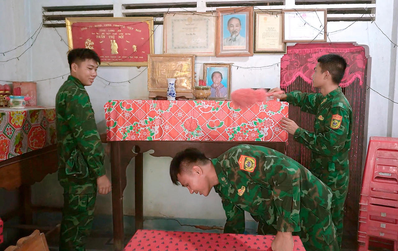 Cán bộ, chiến sĩ Đồn Biên phòng Cửa khẩu Mỹ Quý Tây dọn dẹp nhà cửa, bố trí, sửa sang gian thờ cúng Mẹ Việt Nam Anh hùng Trần Thị Nói. Ảnh: Đinh Quân