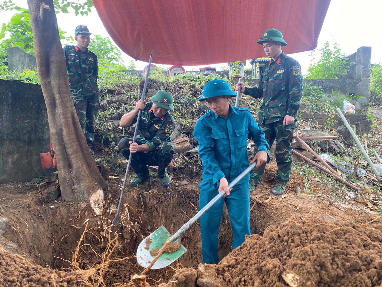 Các lực lượng tham gia khai quật, cất bốc hài cốt liệt sĩ. (Ảnh: Hữu Huỳnh)