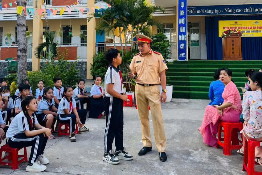 Lực lượng chức năng tuyên truyền luật an toàn giao thông và phòng chống đuối nước cho các em học sinh trong mùa mưa bão. Ảnh Duy Trường