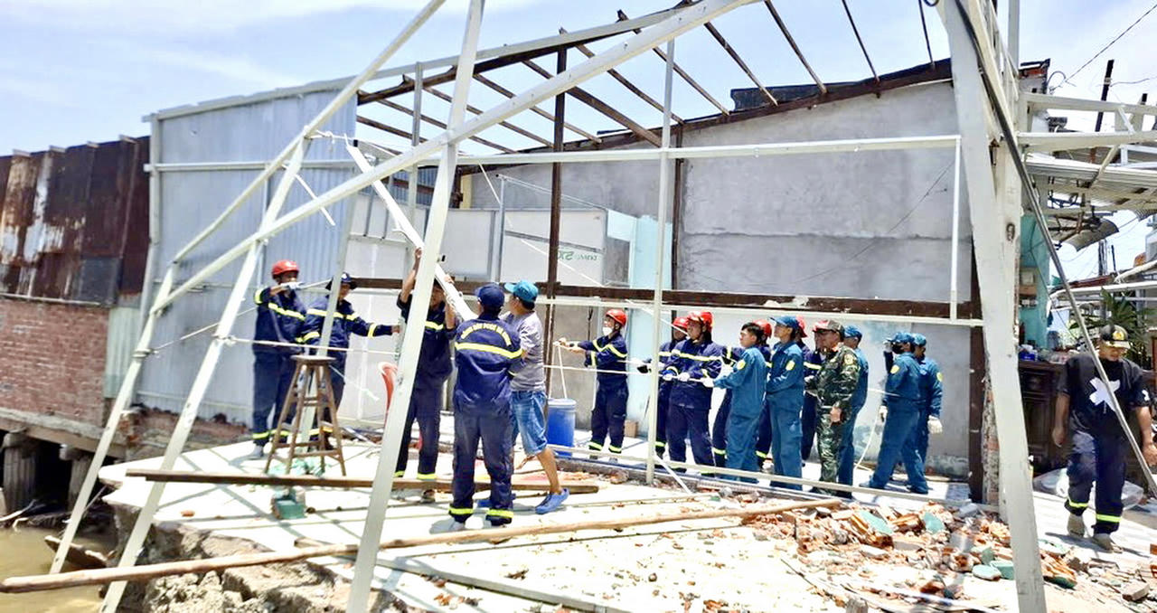 Lực lượng Công an và Quân đội khẩn trương hỗ trợ người dân khắc phục thiệt hại do sạt lở xảy ra tại khóm 13, phường Tân Thành (Ảnh: Hữu Đệ).