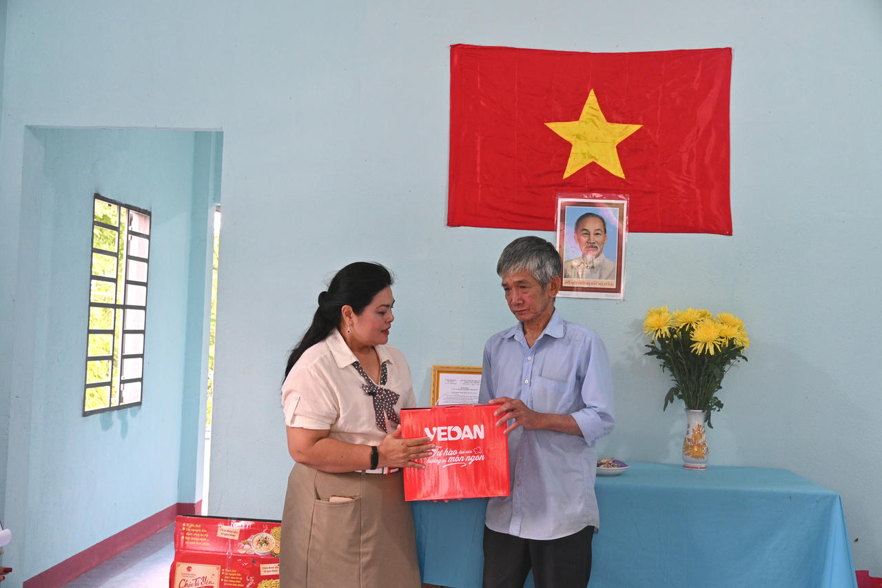 Bà Nguyễn Thu Thủy, đại diện Vedan Việt Nam trao quà cho ông Trần Văn Ân