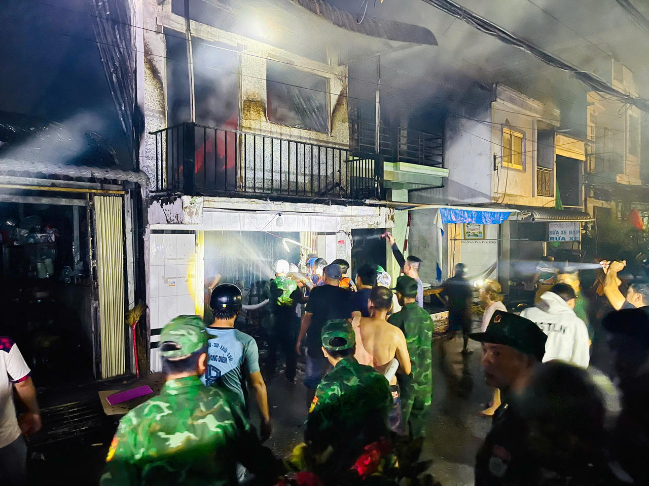 Cán bộ, chiến sĩ Đồn Biên phòng Sông Đốc phối hợp với các lực lượng chức năng khẩn trương dập lửa. (Ảnh: CTV).