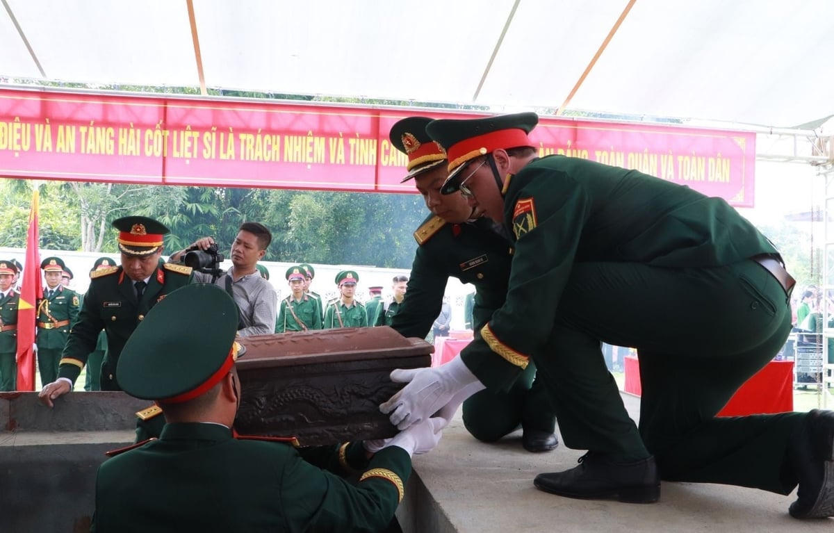 Thực hiện nghi thức an táng liệt sĩ vào phần mộ tập thể. Ảnh: Nguyễn Nga