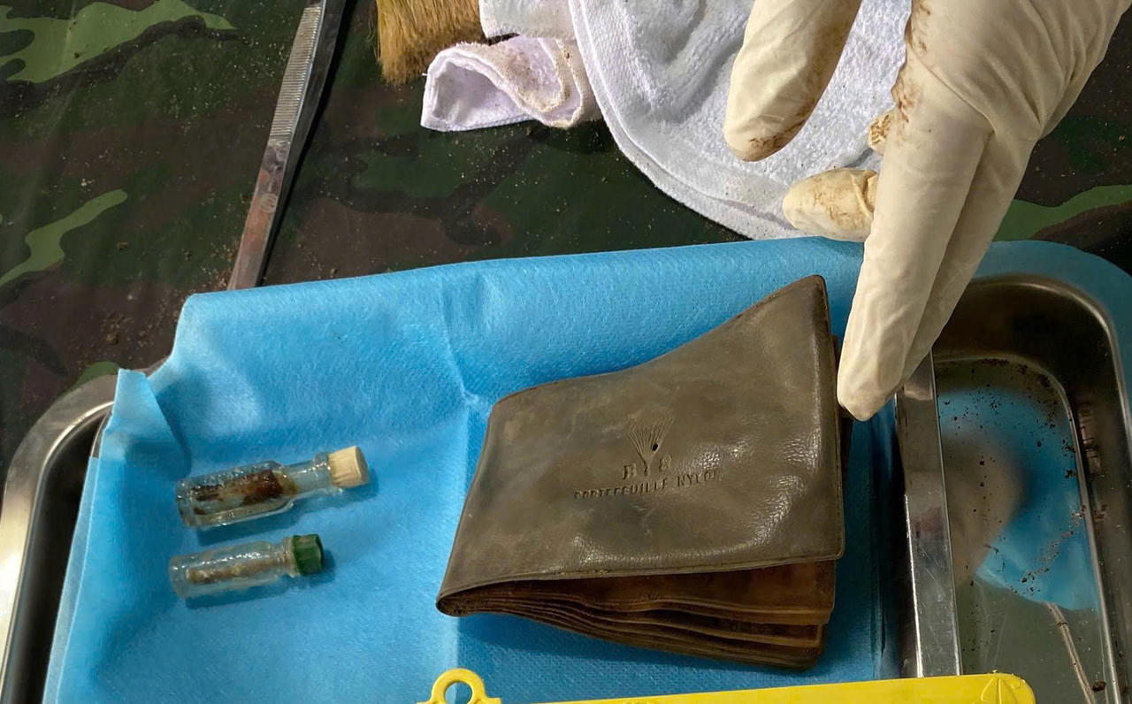 Lực lượng chức năng phát hiện chiếc ví và 2 chai dầu gió. Ảnh Ban chỉ đạo 515.