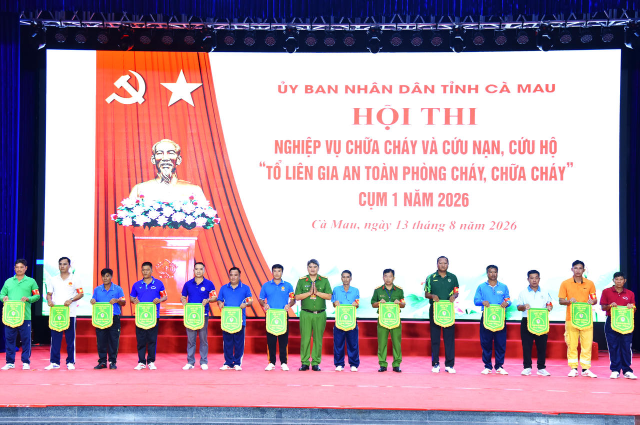 Đại tá Trần Thanh Xuân - Trưởng Phòng Cảnh sát PCCC và CNCH, Phó Trưởng Ban Tổ chức Hội thi trao cờ lưu niệm cho các đội (Ảnh: Hữu Đệ).