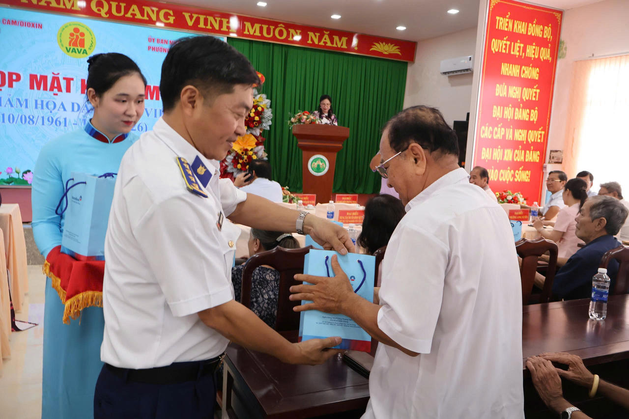 Đại tá Dương Xuân Dũng - Phó Chủ nhiệm Chính trị, Bộ Tư lệnh Vùng Cảnh sát biển 4 trao quà cho các nạn nhân chất độc da cam. Ảnh: Đức Thái