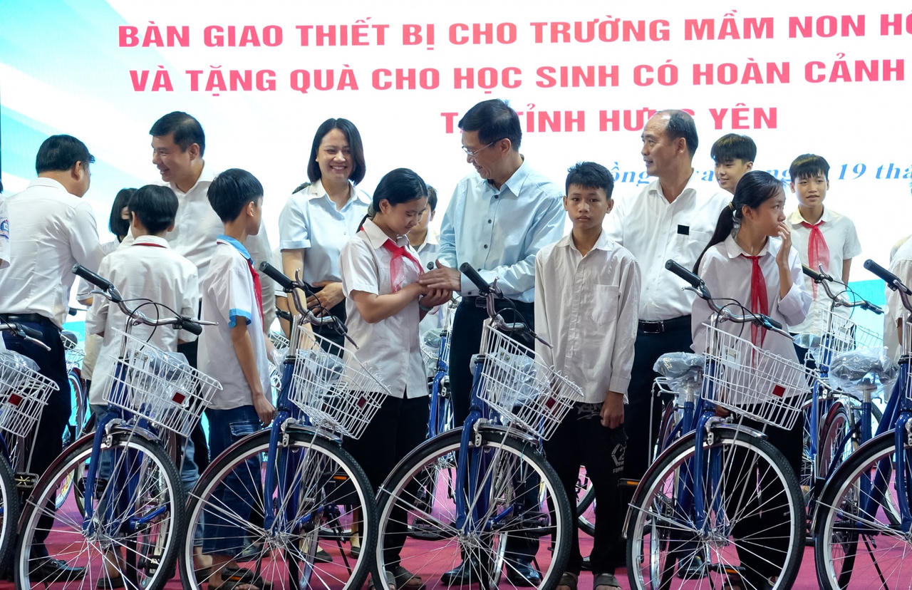 Ông Trần Quang Dũng cùng các đại biểu trao tặng xe đạp cho các em học sinh có hoàn cảnh đặc biệt, đạt thành tích cao trong học tập tại xã Hồng Quang.