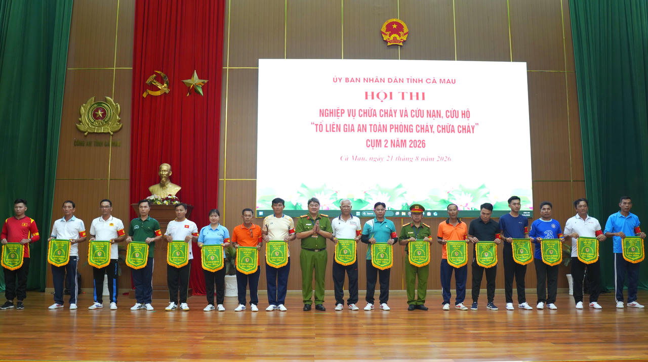 Đại tá Trần Thanh Xuân - Trưởng Phòng Cảnh sát PCCC và CNCH, Phó Trưởng Ban Tổ chức Hội thi trao cờ lưu niệm cho các đội thi (Ảnh: Hữu Đệ).