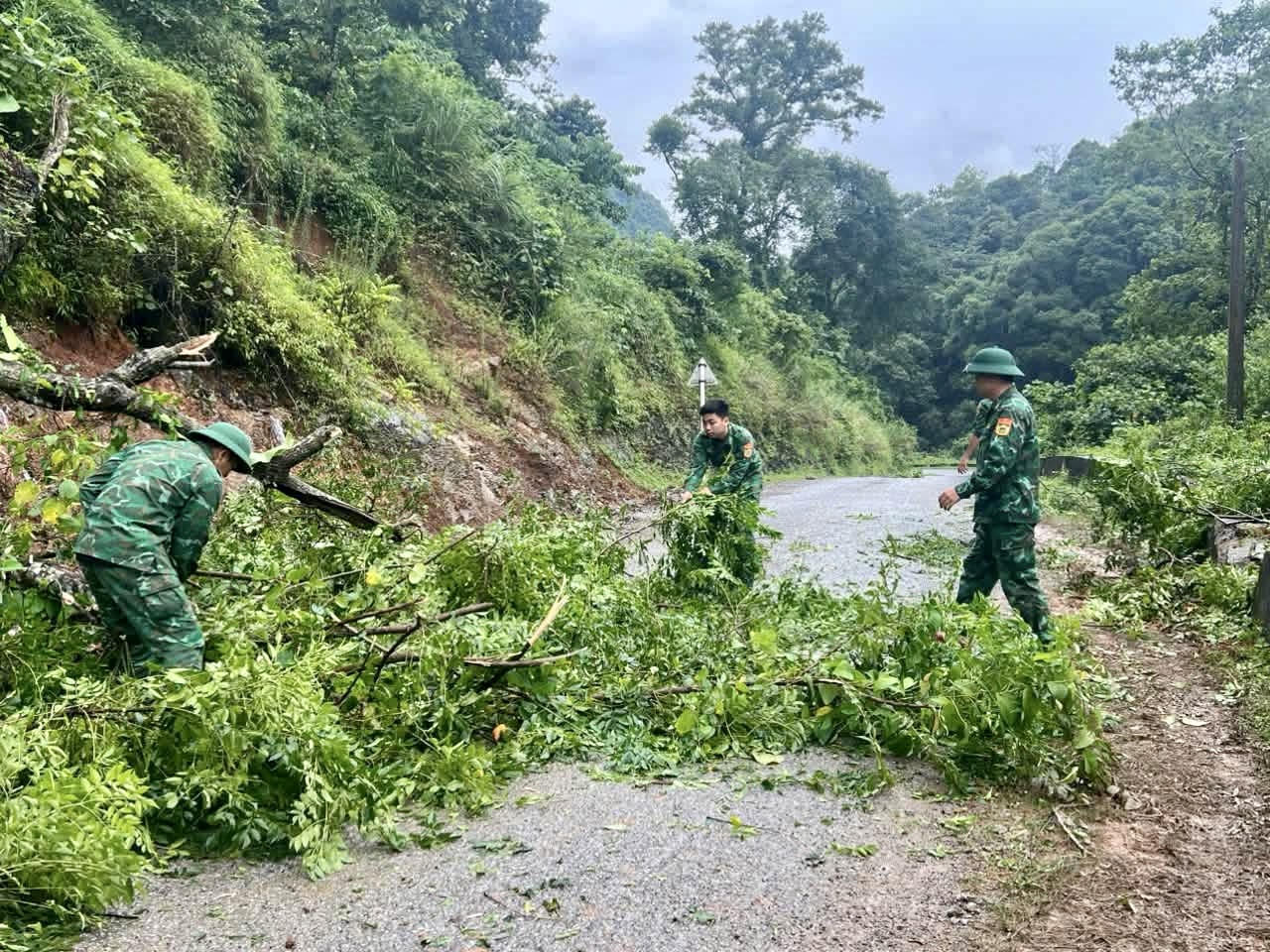Cán bộ, chiến sĩ Đồn BP Quang Long hỗ trợ người dân chặt cây bị đổ do mưa bão. (Ảnh: BPCB)
