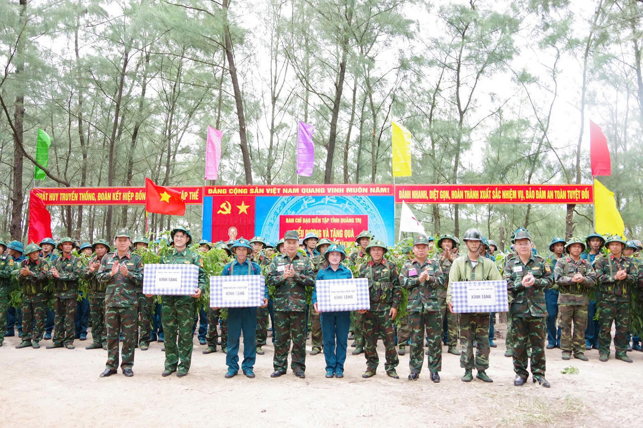 Ban Chỉ đạo diễn tập tỉnh và lãnh đạo cho phường Đông Hà và xã Nam Cửa Việt tặng quà, động viên các lực lượng tham gia thực binh với đề mục “Đại đội bộ đội địa phương phối hợp với các lực lượng tiến công địch đổ bộ đường biển”. (Ảnh: Xuân Diện)