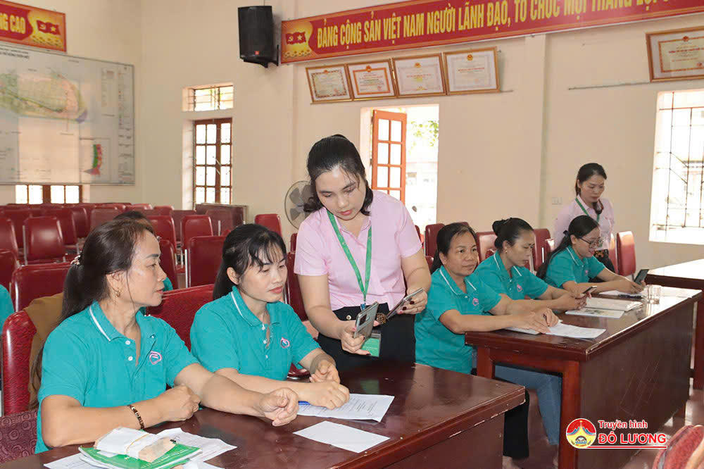 Cán bộ tín dụng NHCSXH Đô Lương tận tình hướng dẫn khách hàng sử dụng vốn vay phát triển sản xuất kinh doanh.