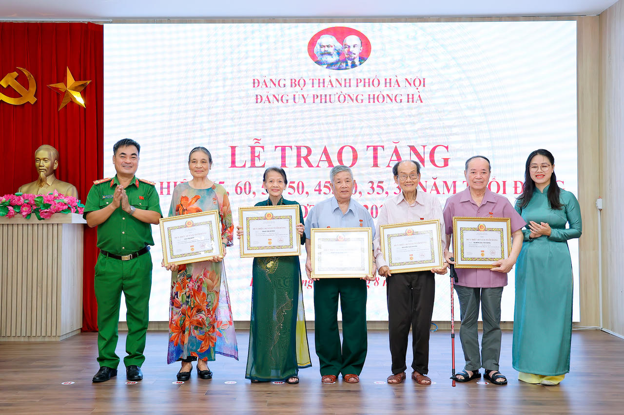 Thượng tá Nghiêm Bá Phước trưởng Công an phường Hồng Hà trao Huy hiệu 60 năm tuổi Đảng cho các đảng viên dịp 2/9.