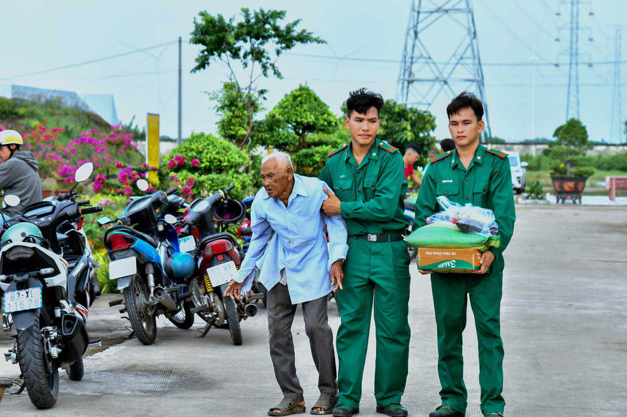 Các chiến sĩ biên phòng hỗ trợ người dân đến nhận quà. Ảnh: Văn Long 