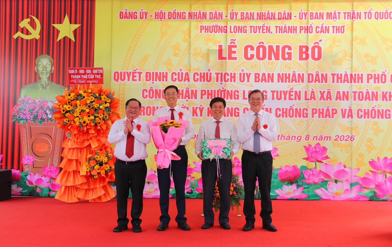 Ông Trương Cảnh Tuyên - Chủ tịch UBND TP Cần Thơ (bìa phải) và ông Trần Quốc Vũ - Phó Chủ tịch HĐND TP Cần Thơ (bìa trái) trao Quyết định, hoa và quà chúc mừng cho lãnh đạo phường Long Tuyền (Ảnh: Đình Thương)