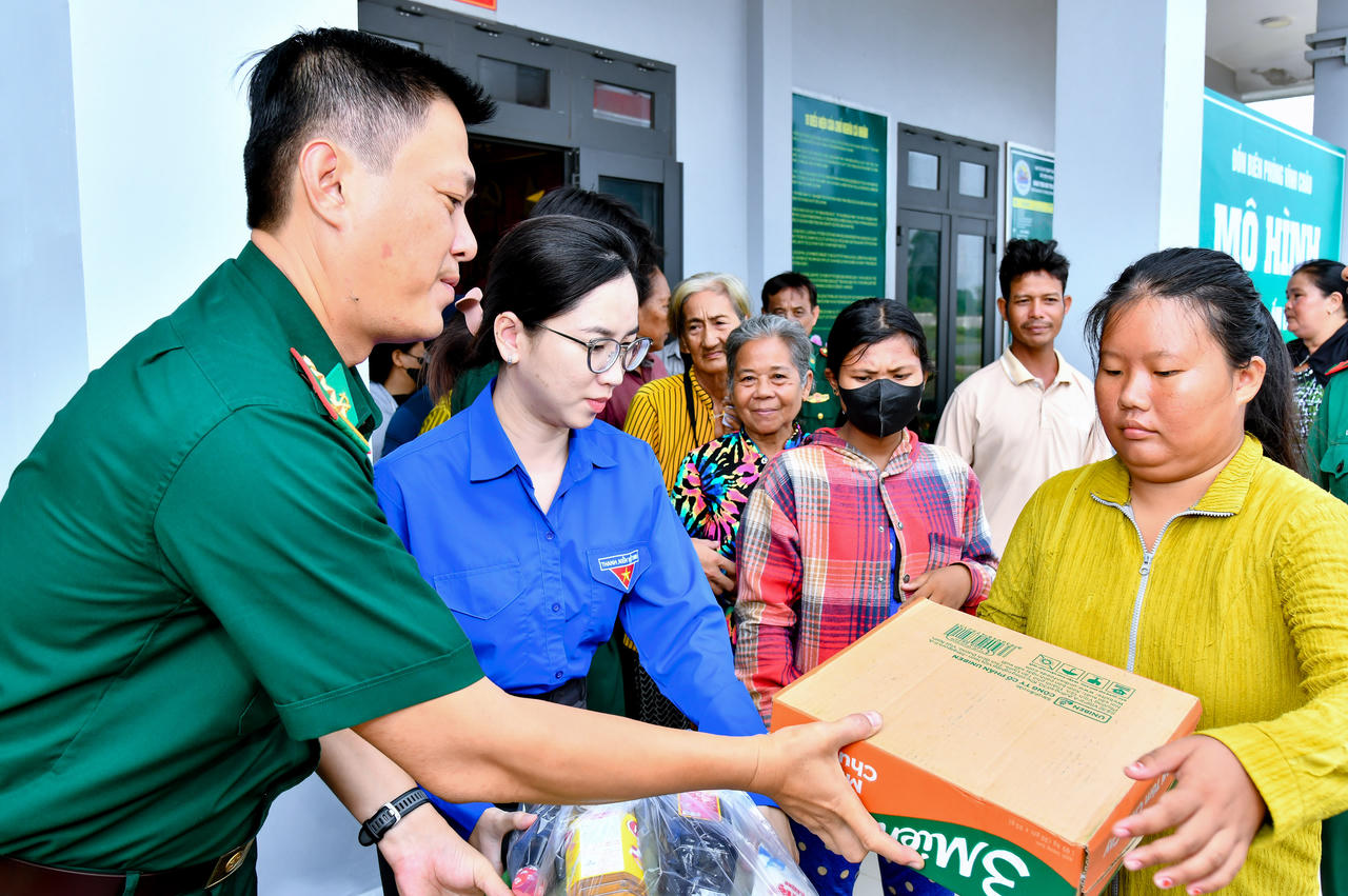 Thượng tá Phạm Nguyễn Thế Phong cùng đại diện mạnh thường quân trao quà cho các em học sinh tại chương trình. Ảnh: Văn Long