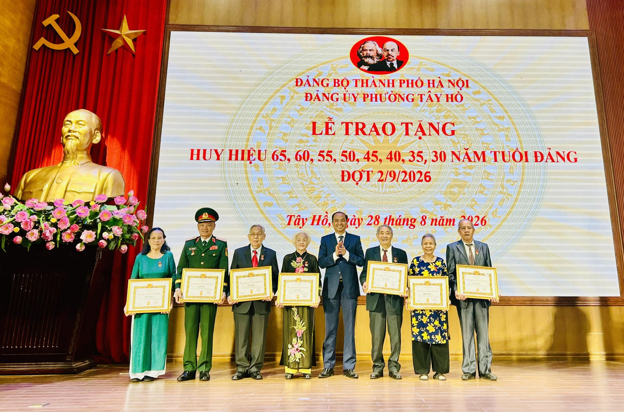 Thành ủy viên, Bí thư Đảng ủy, Chủ tịch HĐND phường Tây Hồ Nguyễn Đình Khuyến  trao Huy hiệu Đảng tới các đảng viên lão thành (Ảnh: Thùy Dương).