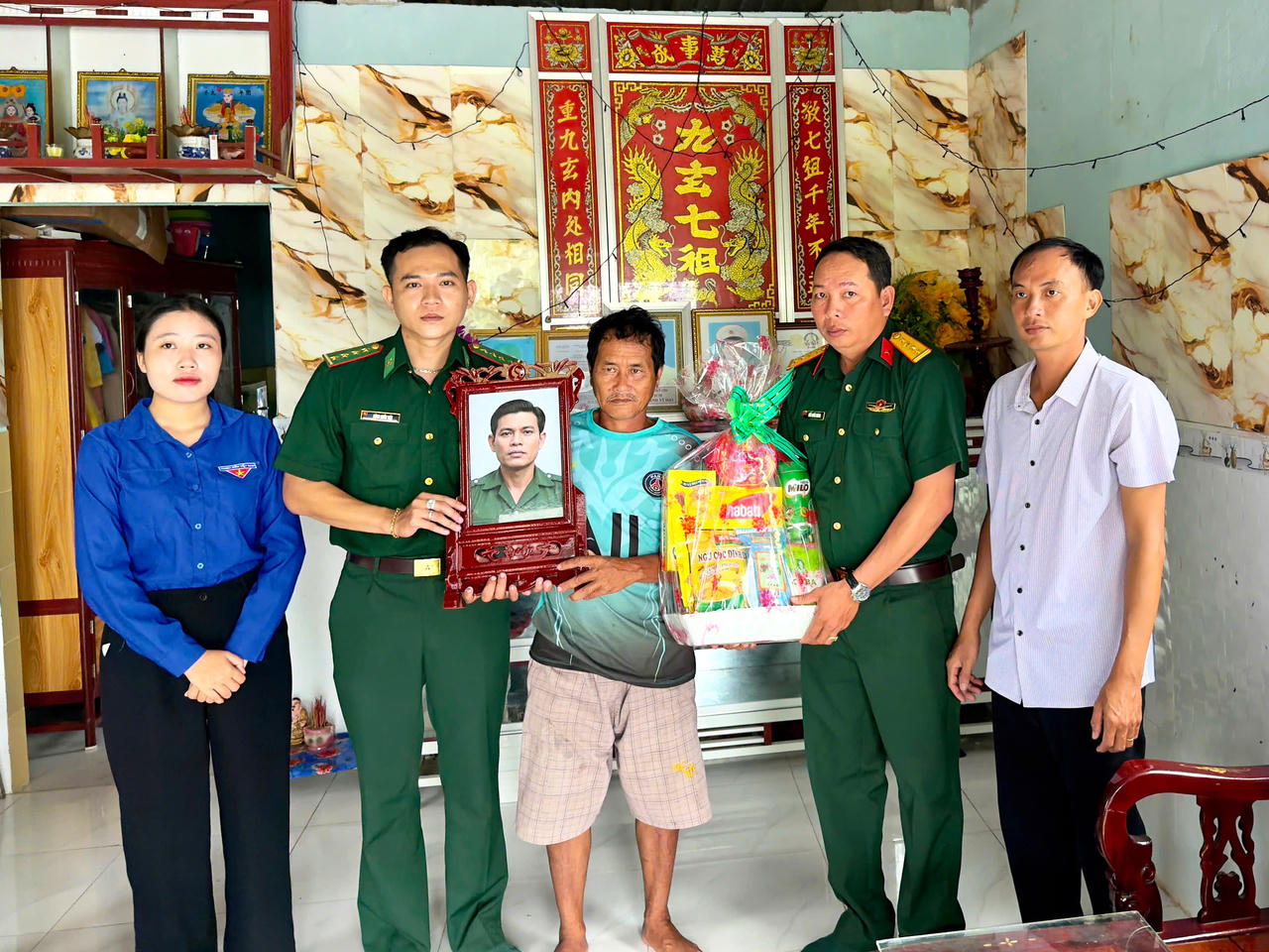 Đồn BP Tam Giang Tây phối hợp với địa phương trao ảnh phục dựng của liệt sĩ và tặng quà thân nhân gia đình liệt sĩ (Ảnh: H.T).