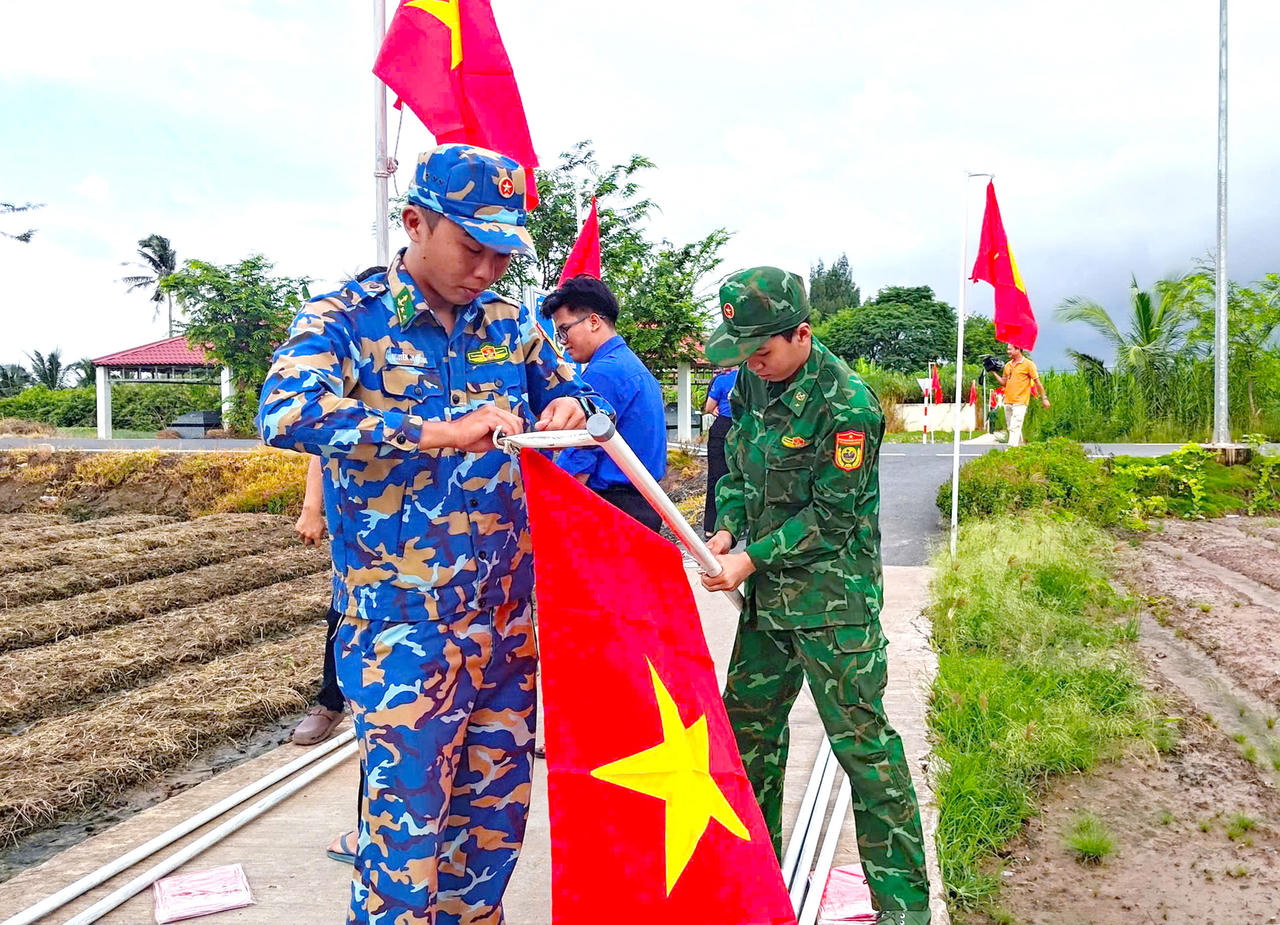 Hải đội Biên phòng 2 phối hợp với đoàn thanh niên địa phương dựng cờ Tổ quốc, chào mừng ngày lễ lớn của đất nước (Ảnh: H.T).