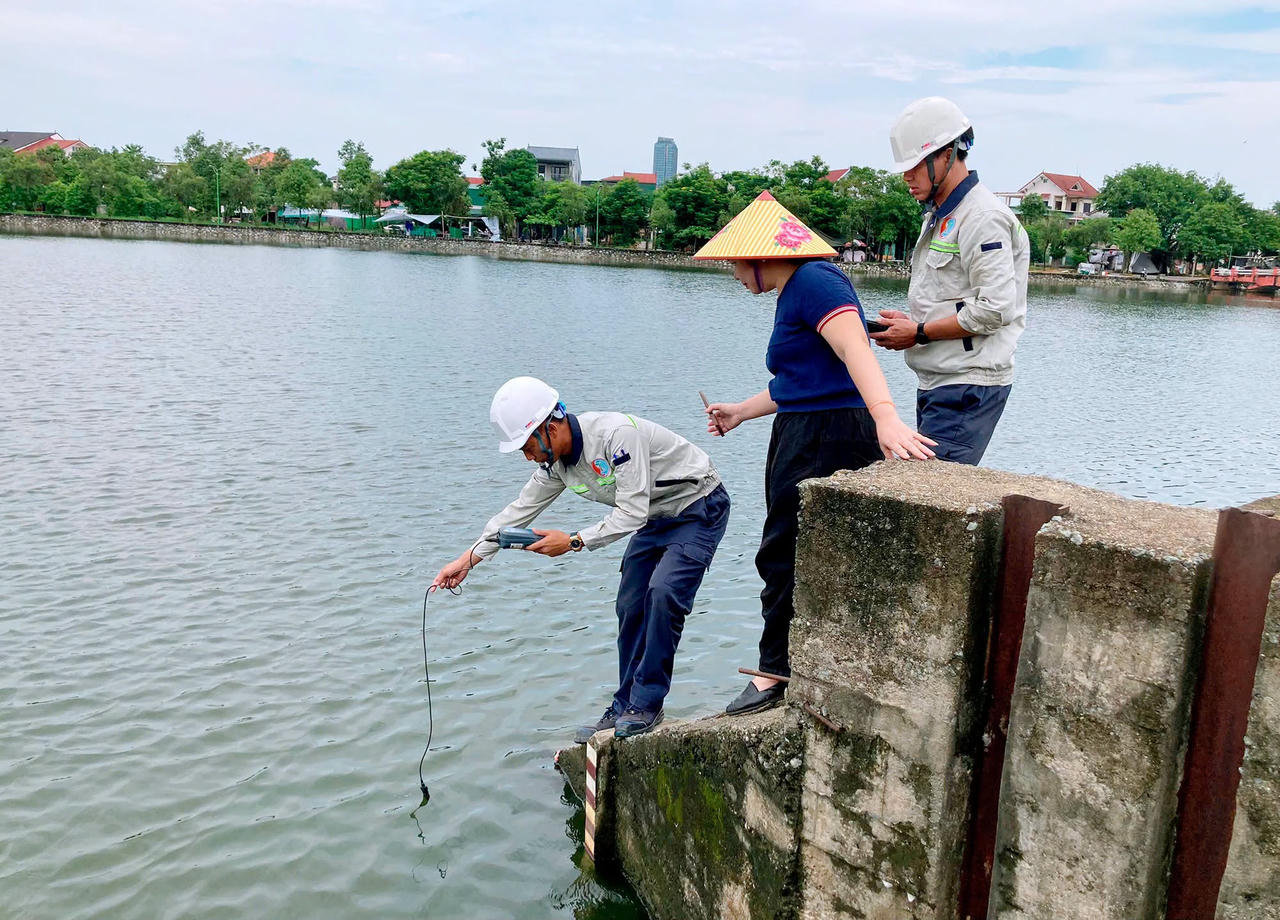 Cơ quan chức năng lấy mẫu nước để xác định nguyên nhân cá chết. Ảnh: Đình Việt