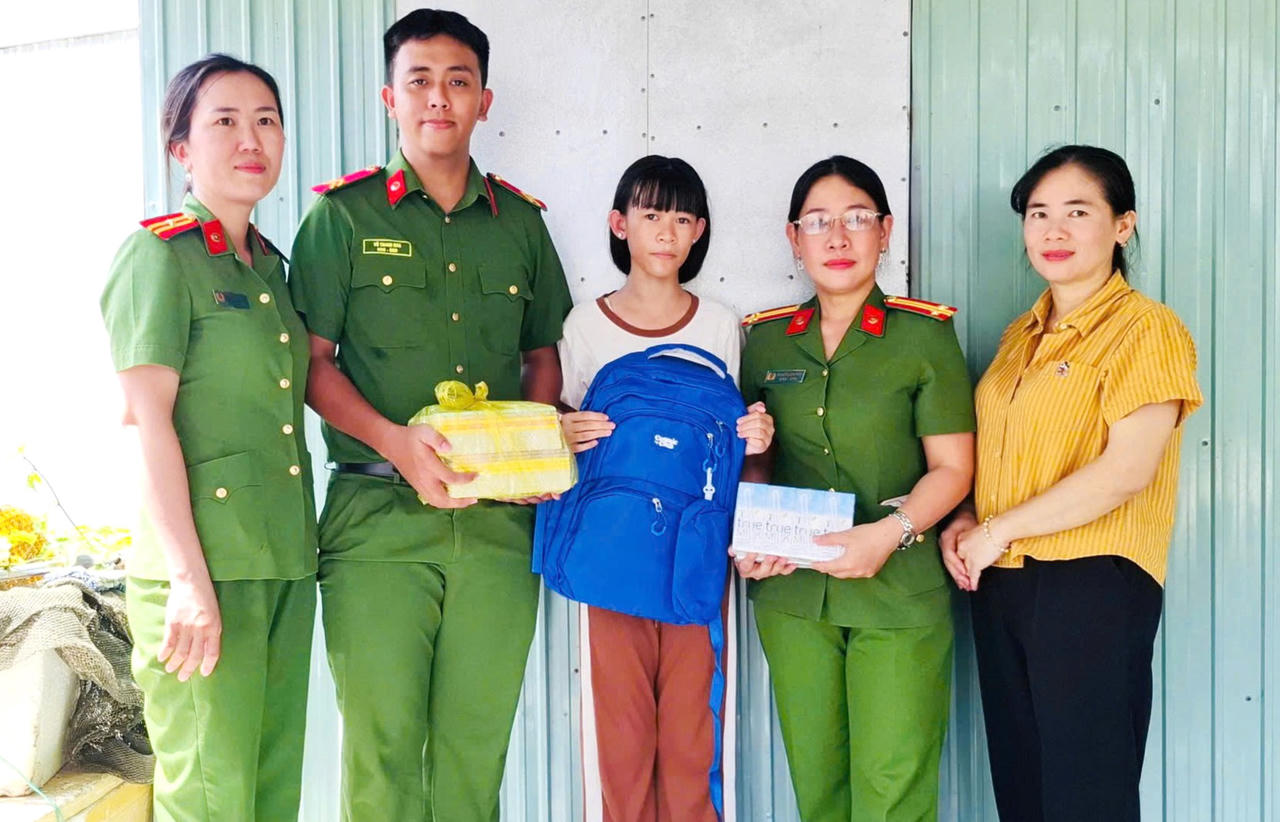 Cán bộ, chiến sĩ Phòng Cảnh sát thi hành án hình sự và hỗ trợ tư pháp Công an tỉnh trao quà cho học sinh có hoàn cảnh khó khăn trên địa bàn xã Hưng Mỹ (Ảnh: HĐ).