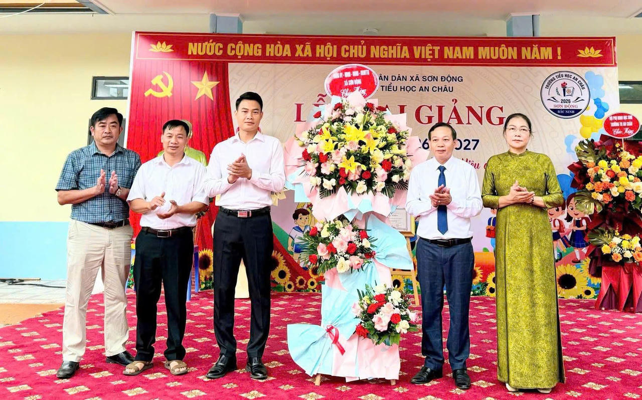 Ông Lục Xuân An - Phó Bí thư Đảng ủy, Chủ tịch UBND xã Sơn Động tặng hoa chúc mừng   Lễ khai giảng Trường Tiểu học An Châu. (Ảnh Vũ Hùng)