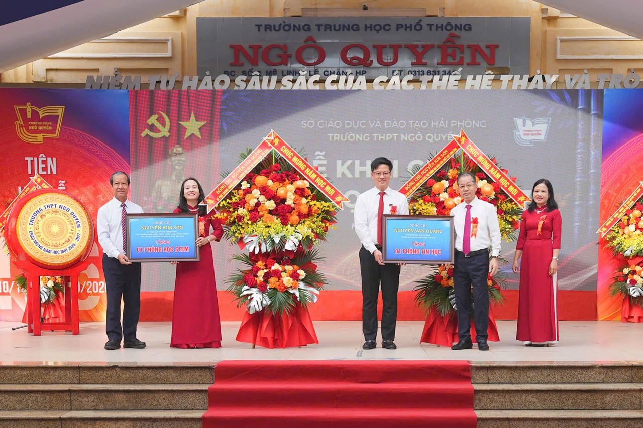 Ông Nguyễn Văn Quảng và ông Nguyễn Kim Sơn trao biển tượng trưng tặng phòng học Tin học và phòng học STEM cho nhà trường. (ảnh Nguyên An)