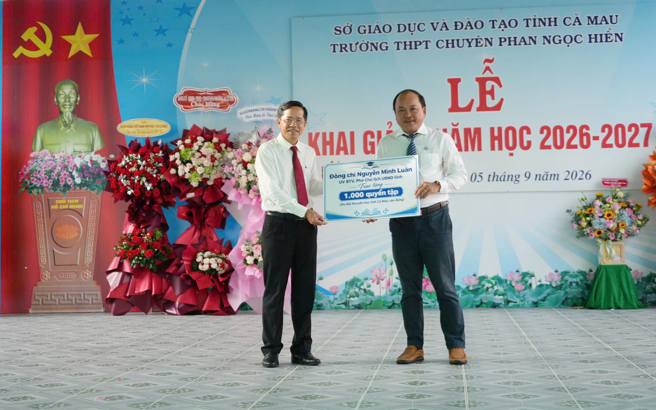 Đại diện lãnh đạo Sở Giáo dục và Đào tạo trao biểu trưng 1.000 quyển tập của ông Nguyễn Minh Luân - Ủy viên BTV Tỉnh ủy, Phó Chủ tịch UBND tỉnh (do Hội Khuyến học tỉnh vận động) tặng Trường THPT Chuyên Phan Ngọc Hiển, phường An Xuyên (Ảnh: T.N).