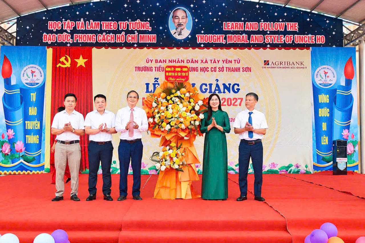 Bí thư Đảng ủy, Chủ tịch HĐND xã Tây Yên Tử Lê Đức Thắng tặng hoa chúc mừng Lễ khai giảng  Trường Tiểu học và Trung học cơ sở Thanh Sơn. (Ảnh Vũ Hùng)