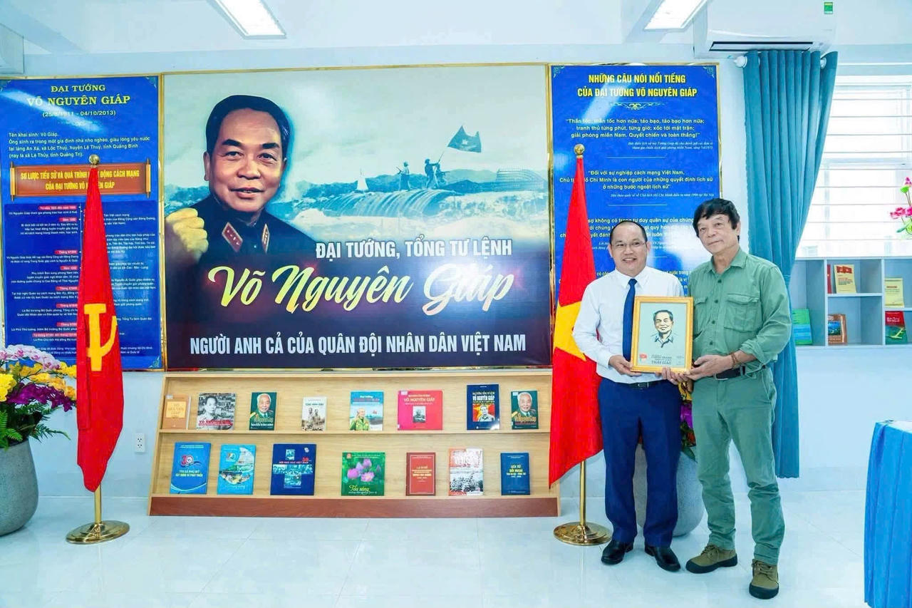Thầy Nguyễn Tùng Giang, Hiệu trưởng Trường THPT Võ Nguyên Giáp và ông Võ Điện Biên, con trai Đại tướng Võ Nguyên Giáp, tại phòng truyền thống của nhà trường. Ảnh: Tiến Dũng.