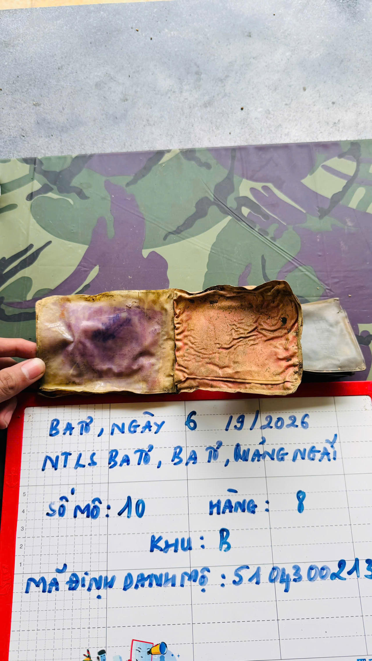 Chiếc ví da lưu thông tin được phát hiện trong mộ liệt sĩ chưa xác định danh tính tại Nghĩa trang Liệt sĩ Ba Tơ (ảnh Vân Anh)