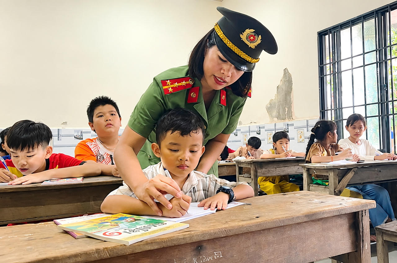 Cán bộ Phòng An ninh nội địa Công an tỉnh Cà Mau tham gia dạy chữ Khmer cho thiếu nhi tại chùa Rạch Giồng, xã Hồ Thị Kỷ trong dịp hè năm 2026 (Ảnh: H.Đ).