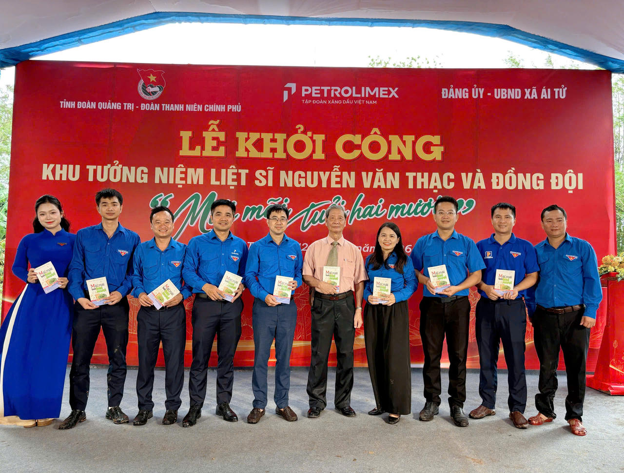 Các đại biểu chụp ảnh lưu niệm cùng ông Nguyễn Văn Thục, anh trai liệt sĩ Nguyễn Văn Thạc, trên tay cầm cuốn nhật ký Mãi mãi tuổi hai mươi. (Ảnh: Tỉnh đoàn Quảng Trị)