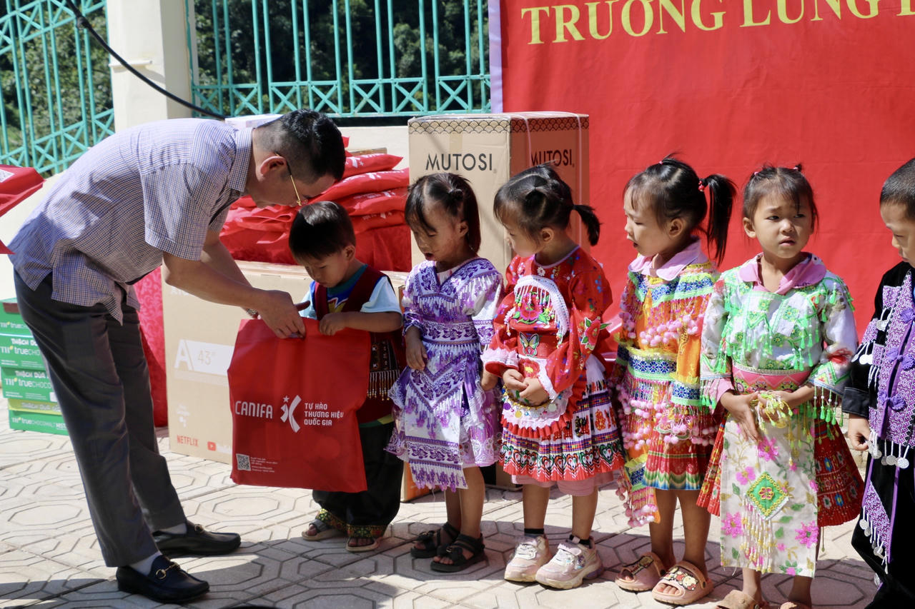 Tiến sĩ Vũ Hoài Nam, Bí thư Đảng ủy, Tổng Biên tập Báo Pháp luật Việt Nam tặng quà cho các em học sinh. (Ảnh: Lê Hanh)