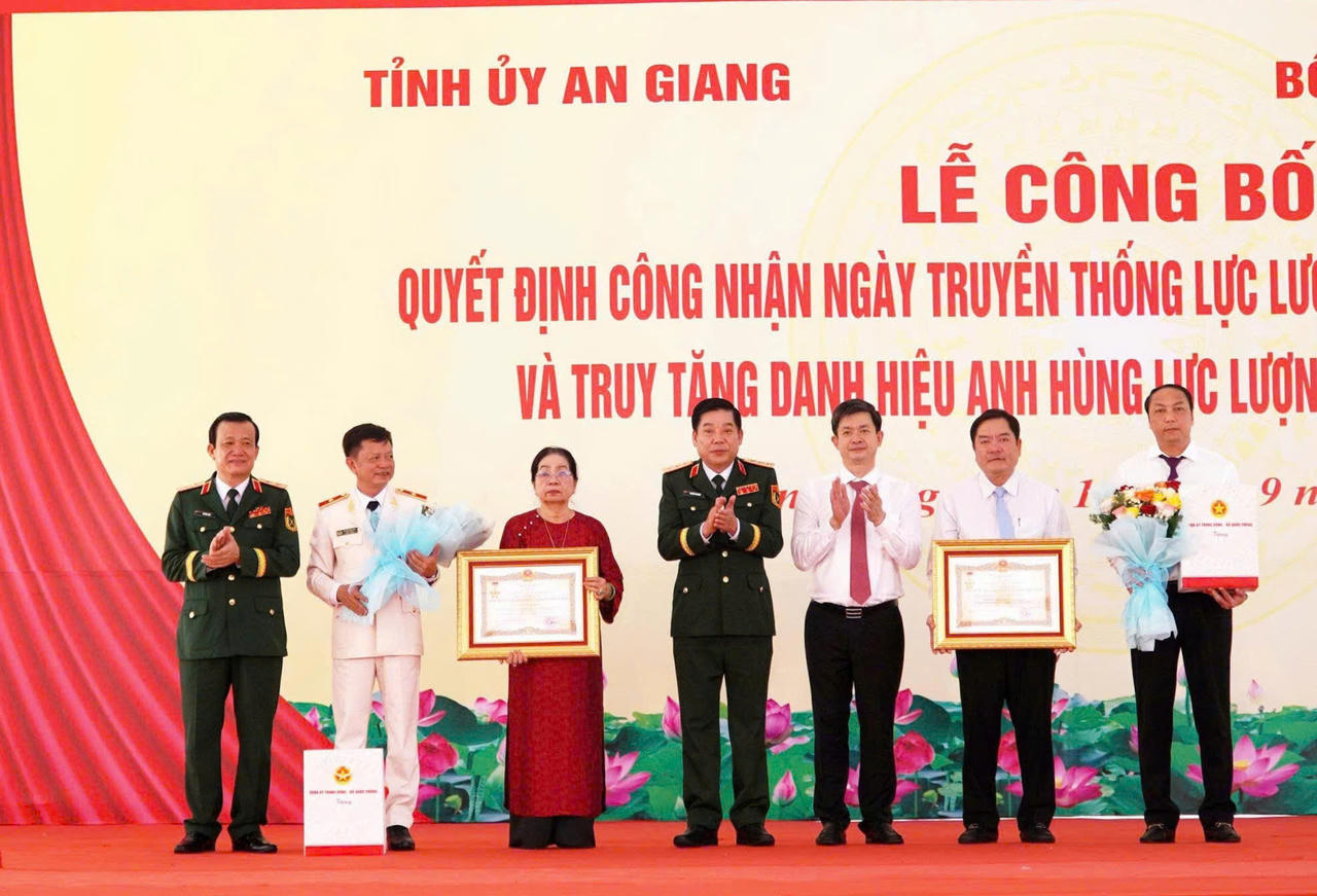 Thượng tướng Nguyễn Văn Gấu, Ủy viên Trung ương Đảng, Thứ trưởng Bộ Quốc phòng và Trung tướng Hồ Văn Thái, Chính ủy Quân khu 9 trao quà tặng thân nhân hai gia đình. Ảnh: Châu Sa